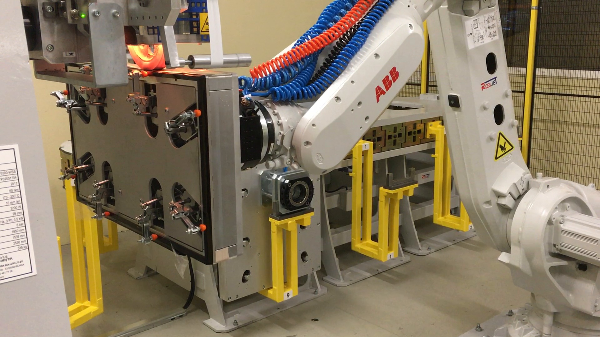 ABB-Industrieroboter mit einer großflächigen Spannvorrichtung an einer Bearbeitungsstation